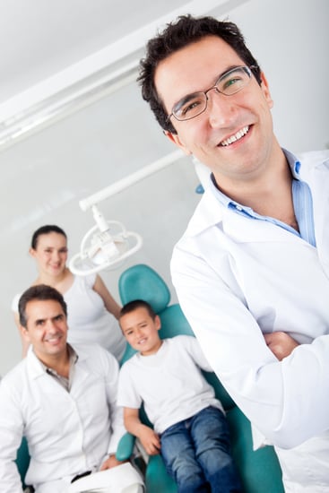 Pediatric male dentist with his team and a young patient